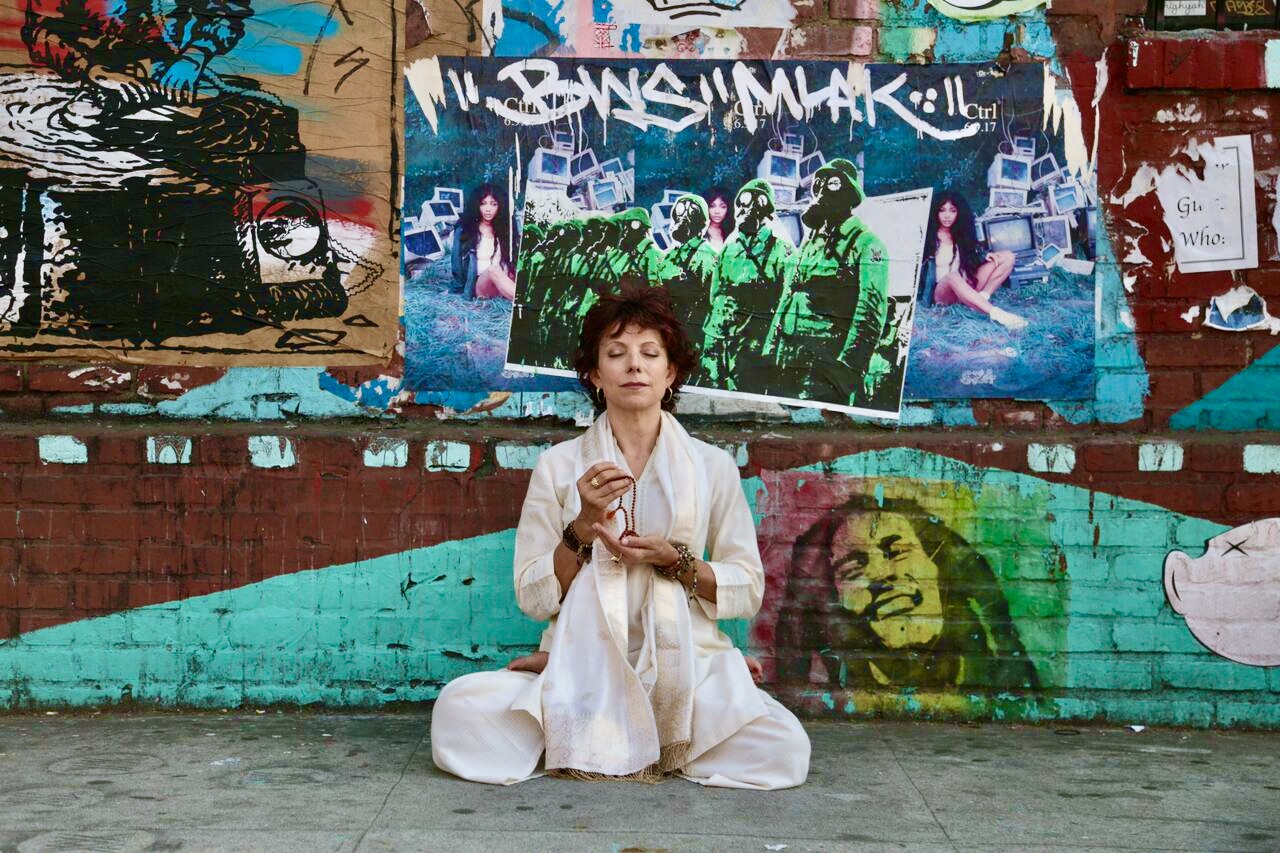 Jeanne Heileman sitting in front of graffiti wall